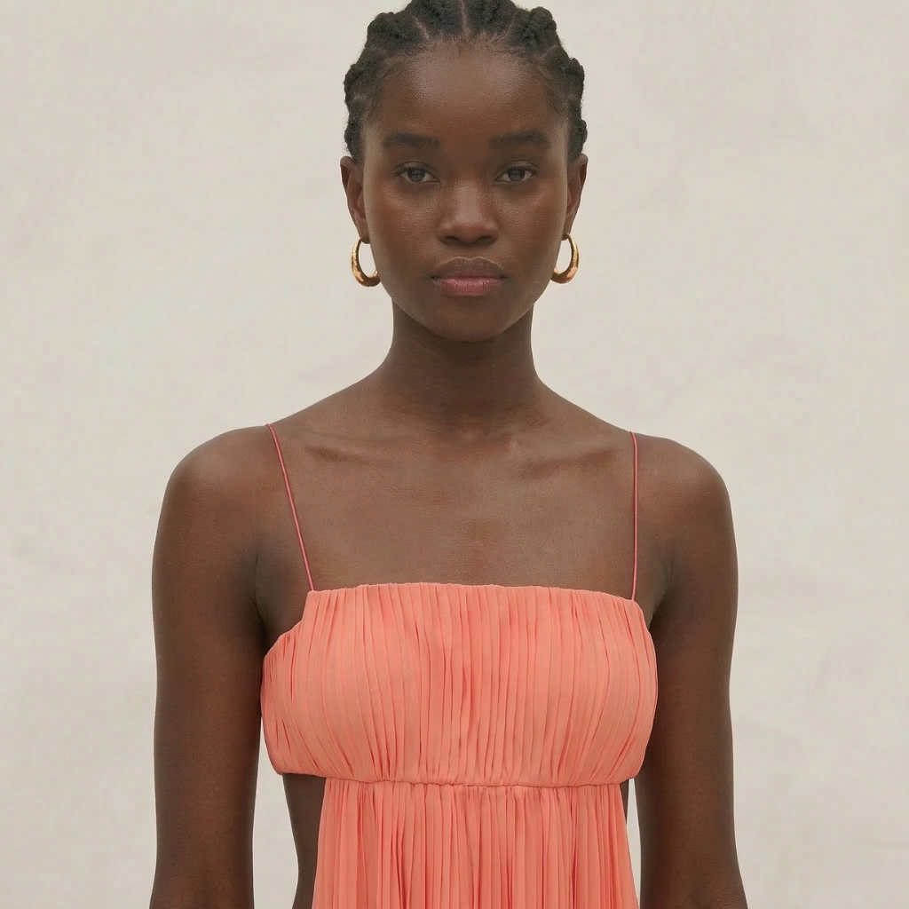 Woman wearing a coral dress against a plain background