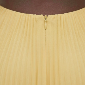 Close-up of a beige skirt with a gold zipper on a dark background