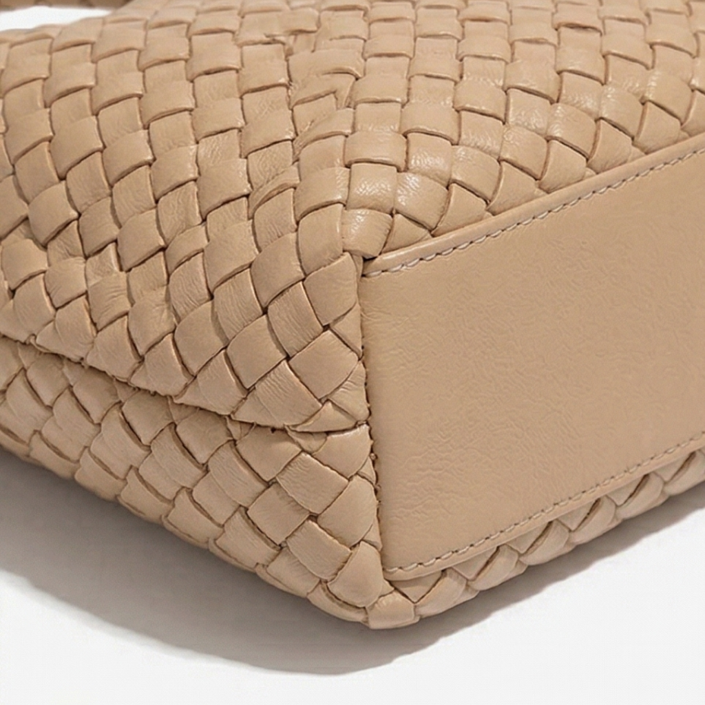 Close-up of a beige woven handbag on a white background