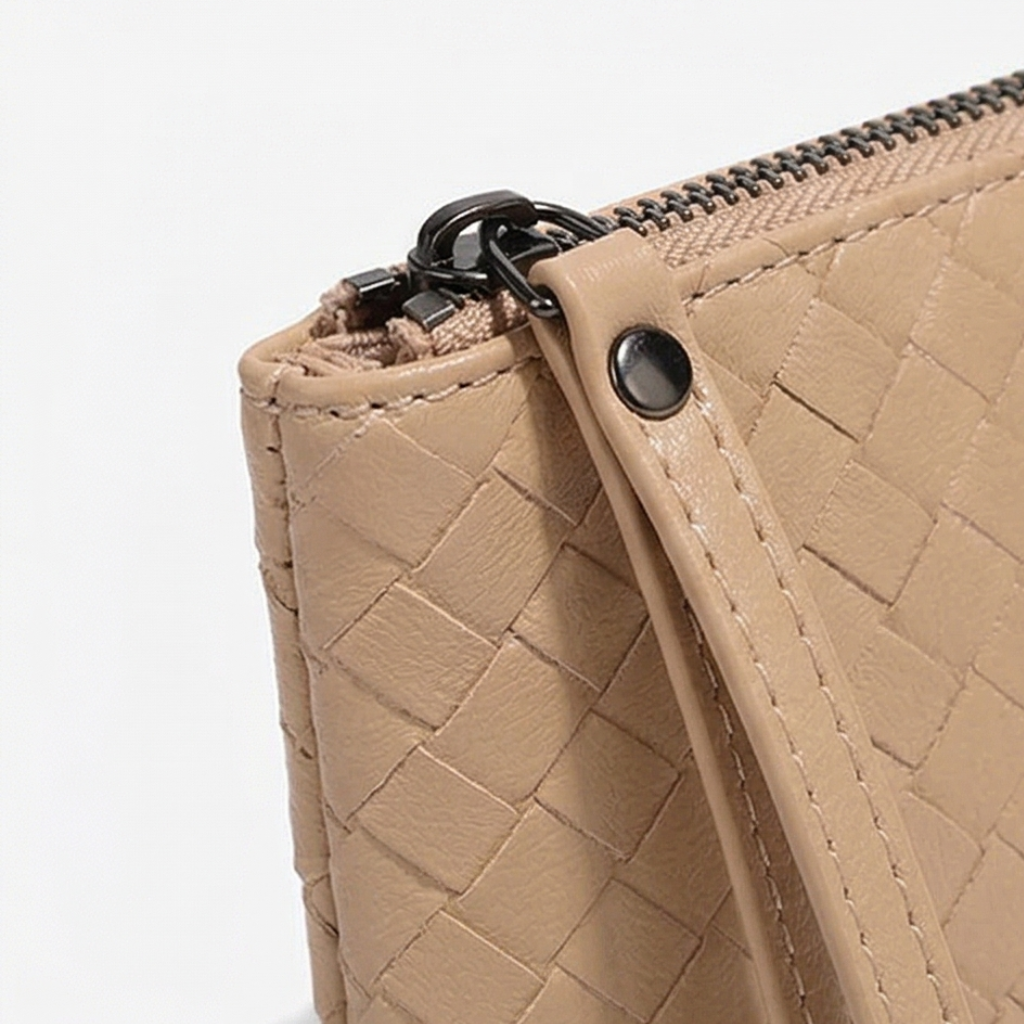 Close-up of a beige woven handbag with a zipper on a white background
