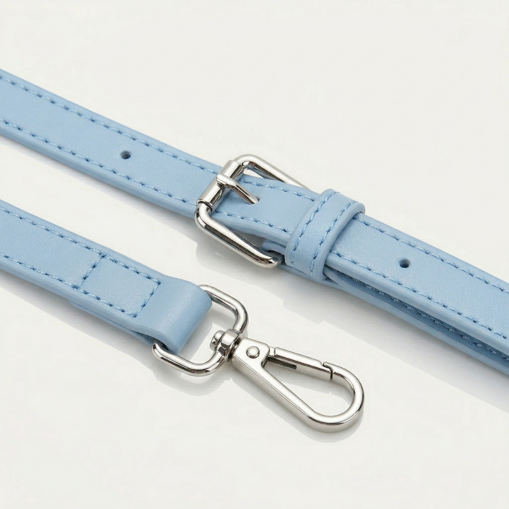 Light blue leather belt with silver hardware on a light gray background