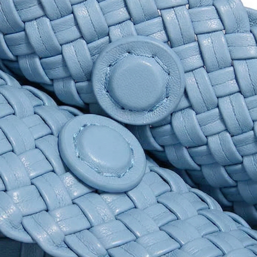 Close-up of blue woven sandals with button details