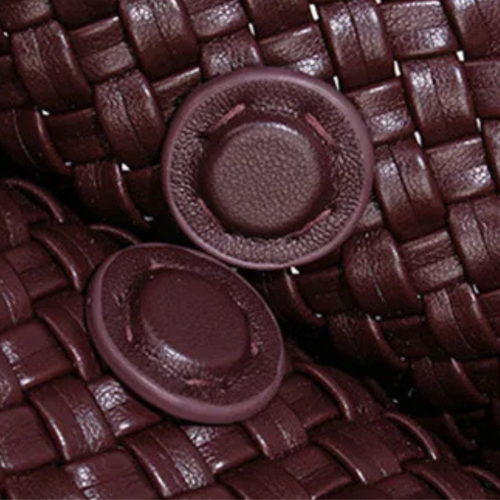 Close-up of brown woven material with two round, textured buttons.