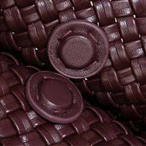 Close-up of brown woven material with two round, textured buttons.