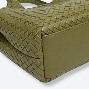 Close-up of a green woven handbag on a white background