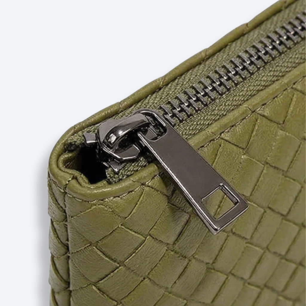 Close-up of a green textured wallet with a silver zipper on a white background