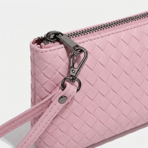 Pink woven handbag with a zipper on a white background