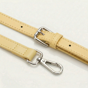 Two beige leather straps with silver hooks on a light gray background