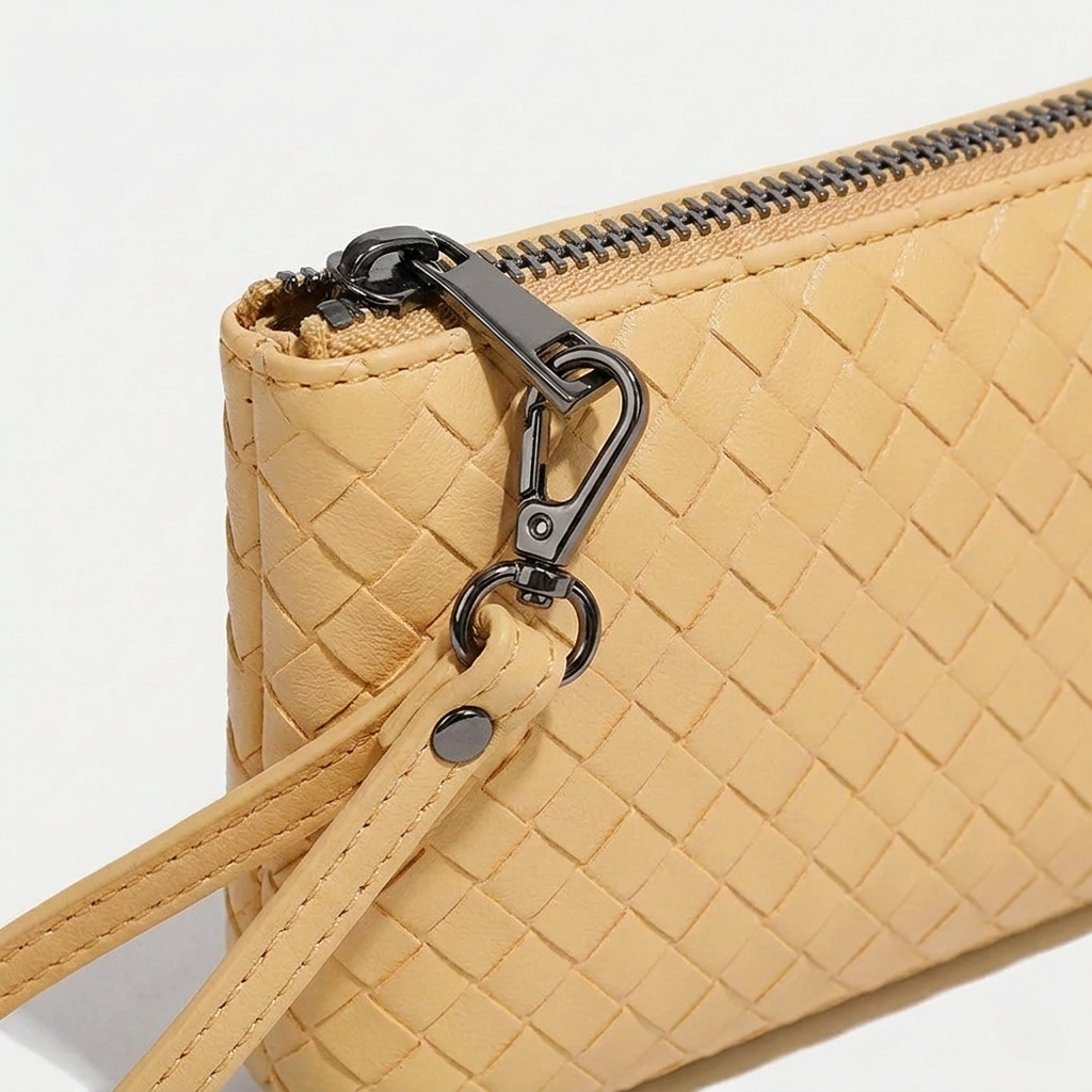 Beige woven handbag with a black zipper on a white background