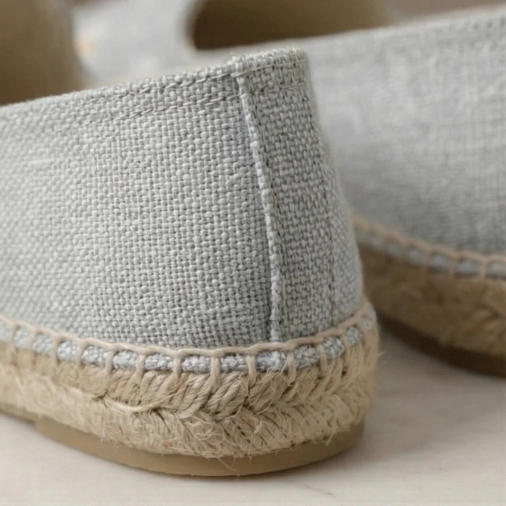 Close-up of gray espadrille shoes with jute sole on a light background