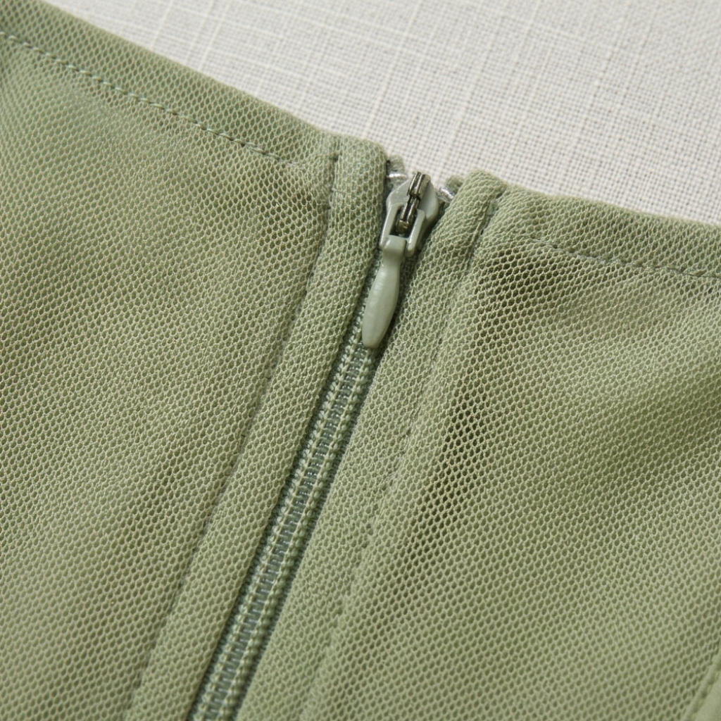 Close-up of a green zipper on a textured fabric background