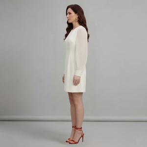 Woman wearing a white dress against a gray background