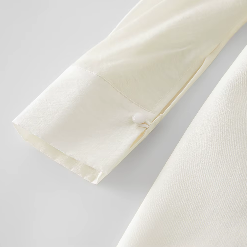 Close-up of a white fabric with a button on a light gray background