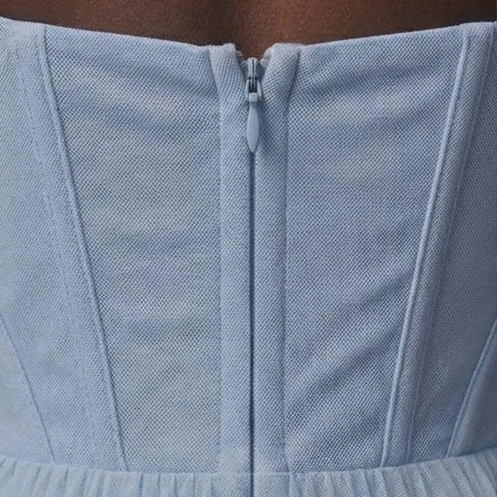 Close-up of a light blue textured fabric with a zipper.