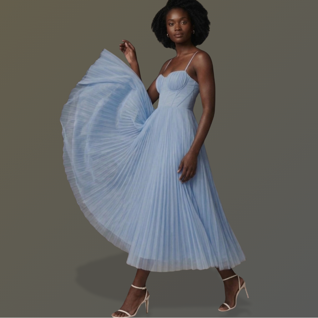 Woman wearing a light blue pleated dress on a gray background