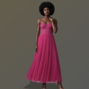 Woman wearing a pink dress against a gray background