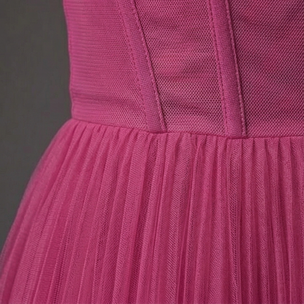 Close-up of a pink textured dress with a dark gray background