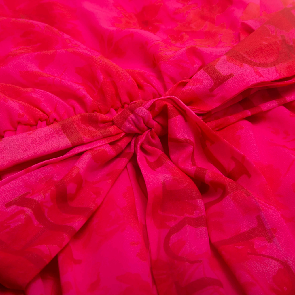 Close-up of bright pink fabric with intricate patterns