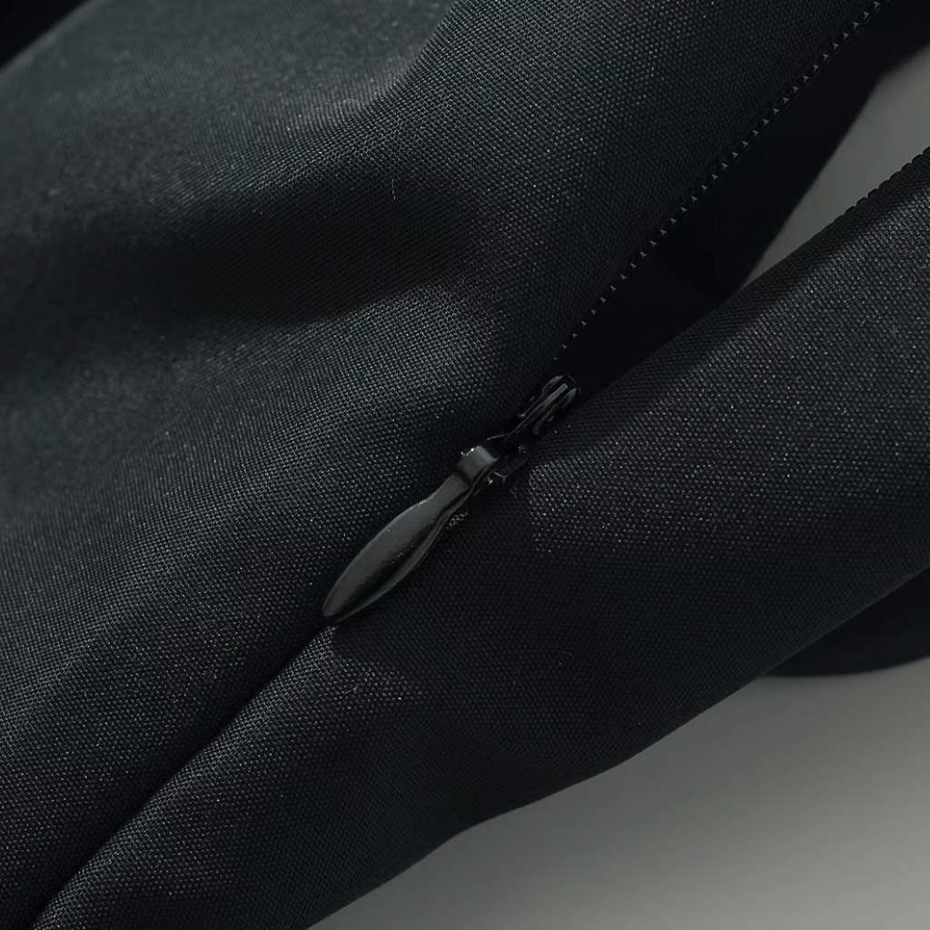 Close-up of a black bag with a zipper on a light gray background