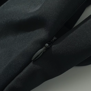 Close-up of a black bag with a zipper on a light gray background