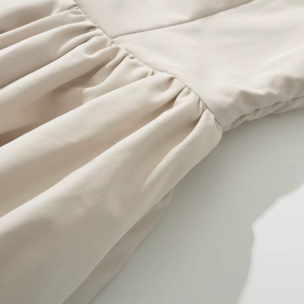 Close-up of beige fabric with a subtle texture on a light background