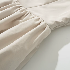 Close-up of beige fabric with a subtle texture on a light background