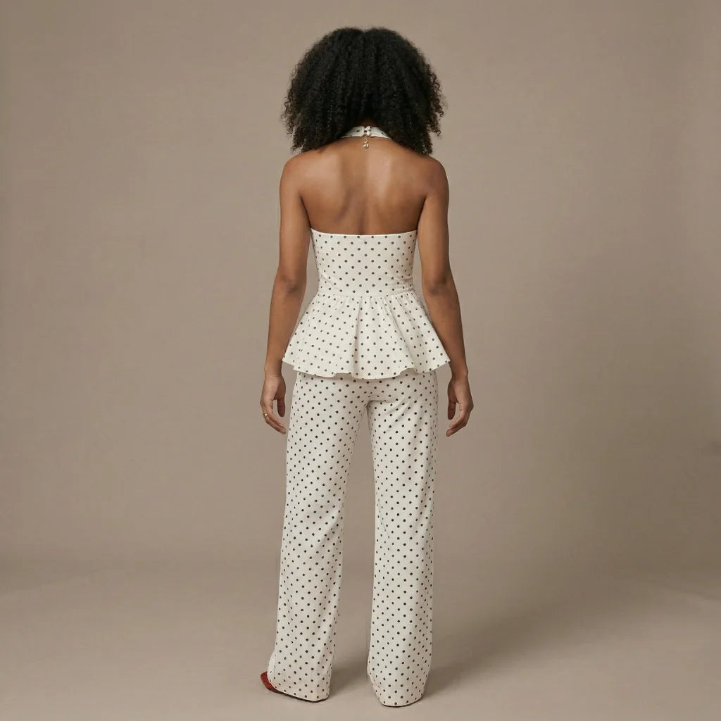 Woman wearing a polka dot strapless top and pants on a beige background