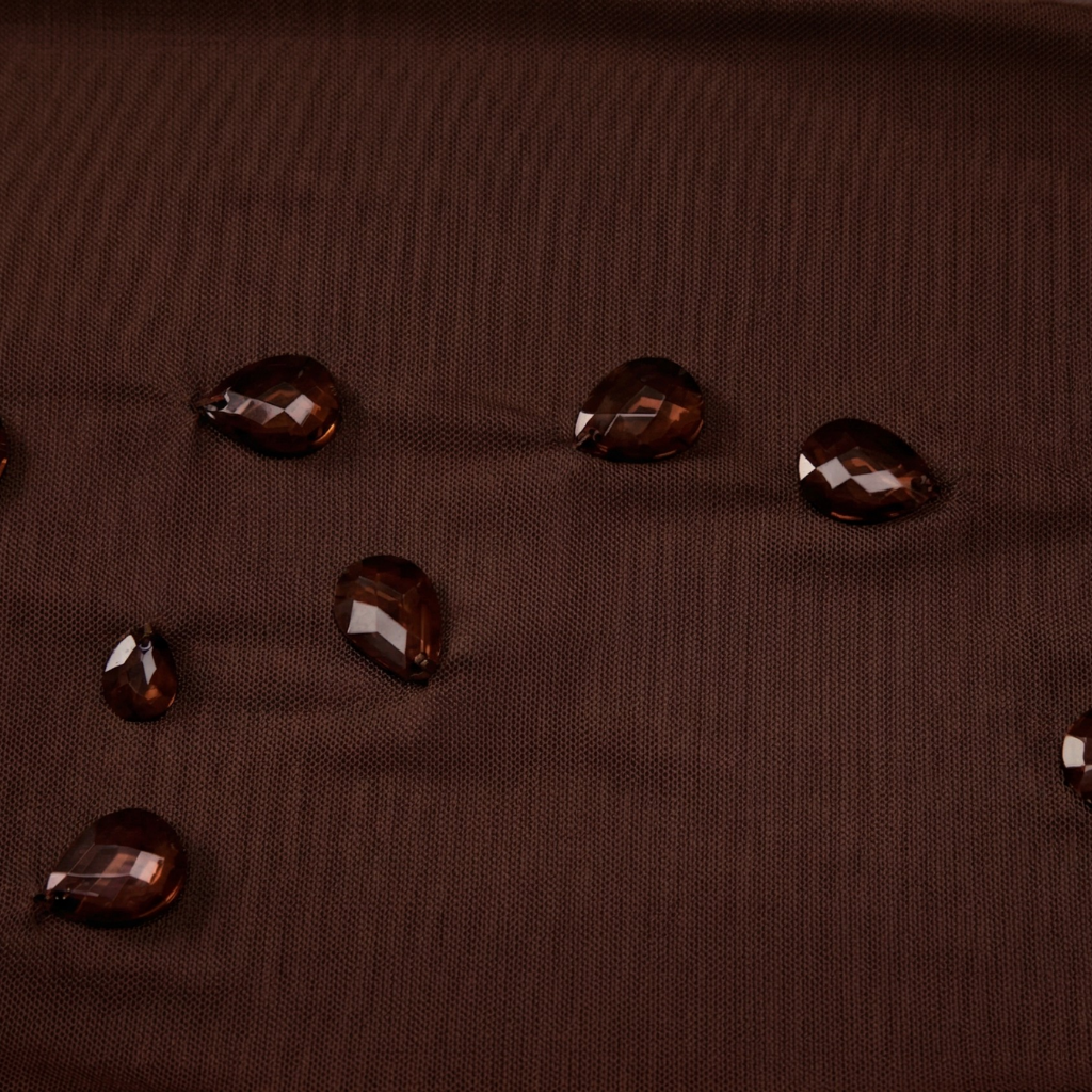 Brown fabric with water droplets on a textured surface