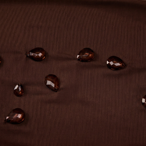 Brown fabric with water droplets on a textured surface