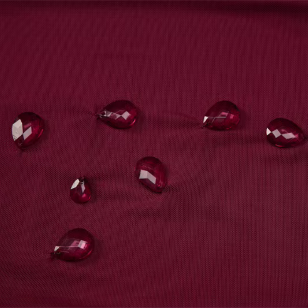 Red water droplets on a textured red surface