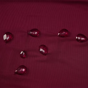 Red water droplets on a textured red surface