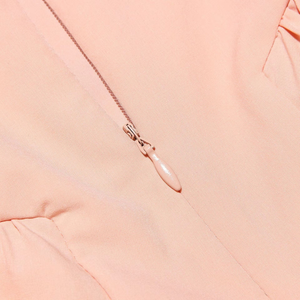 Close-up of a pink zipper on a pink fabric background