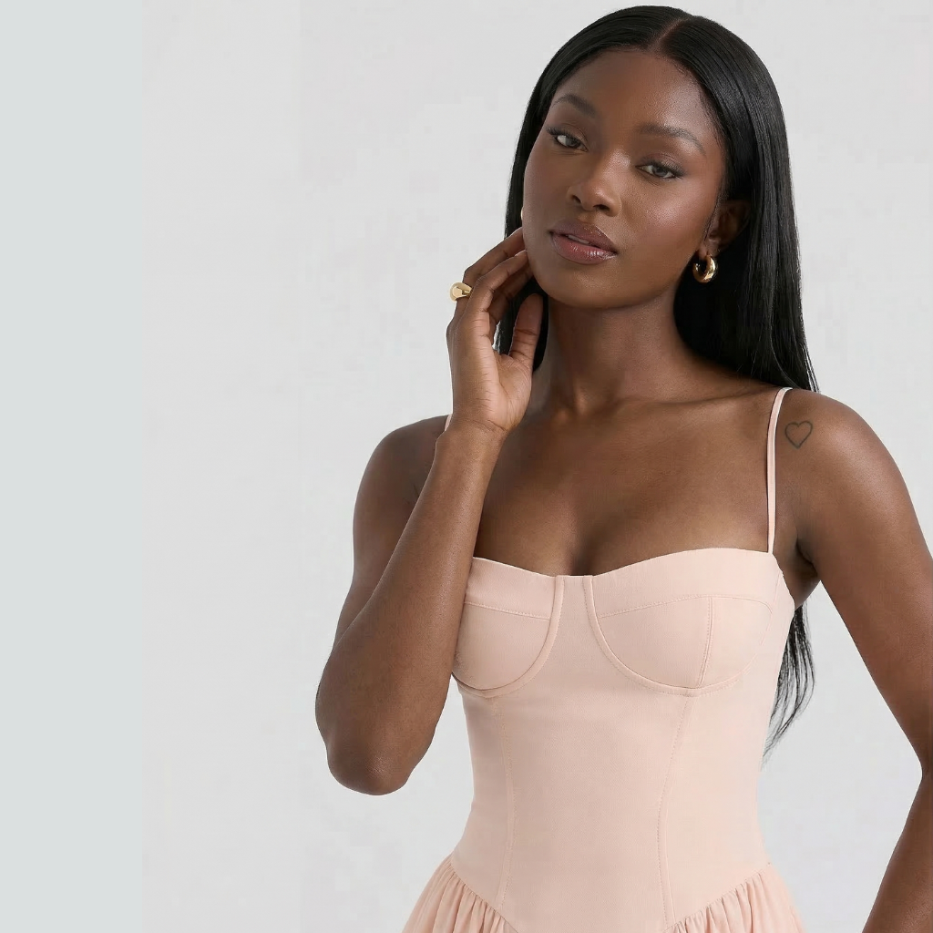 Woman wearing a beige dress against a plain background