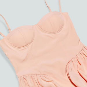 Light pink dress with thin straps on a light blue background